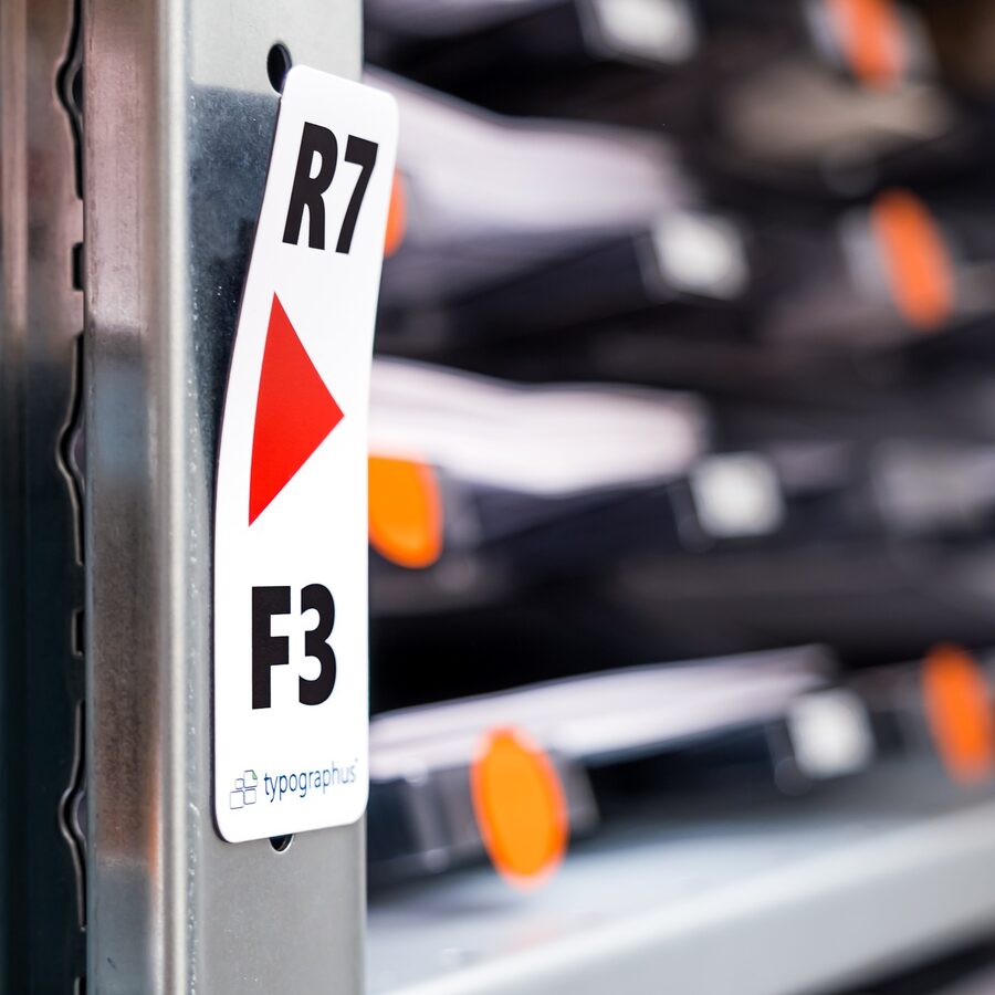 Bedruckte Magnetfolie als Regaletikett R7 F3 mit Pfeil und Logo an einem Stahlregal