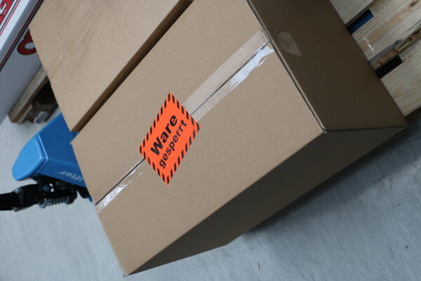 Versandaufkleber Ware gesperrt auf Karton mit Hubwagen  -  Logistik-Etiketten von Typographus